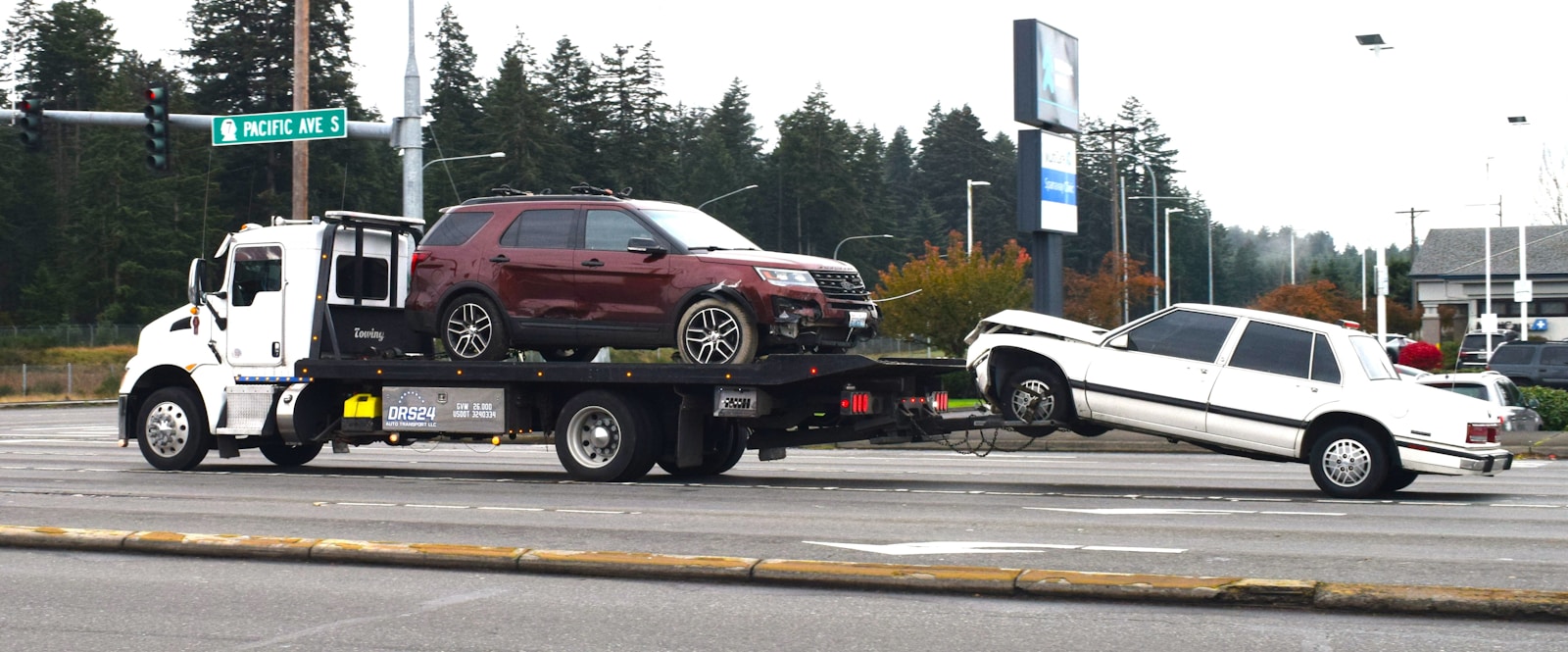 A tow truck towing a car on a flatbed, auto